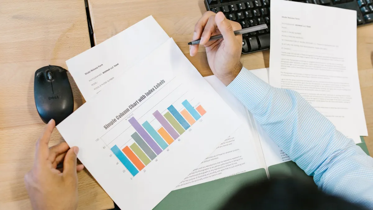 A financial report open on a desk showing a coloured bar chart